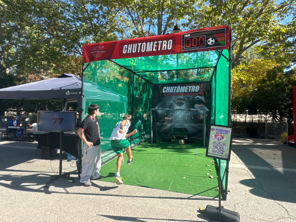 Participantes en una estación decorada con branding de Heineken y temática de fútbol, en un evento deportivo al aire libre.
