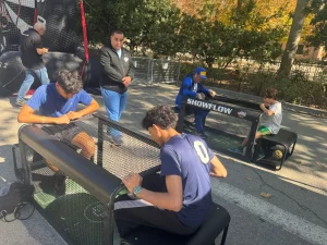 Persona jugando frente a una pantalla interactiva con temática de fútbol, utilizando un balón real como parte del sistema.