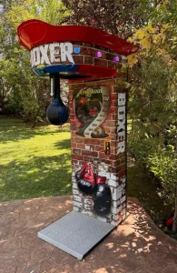 Máquina de boxeo roja instalada sobre césped al aire libre.