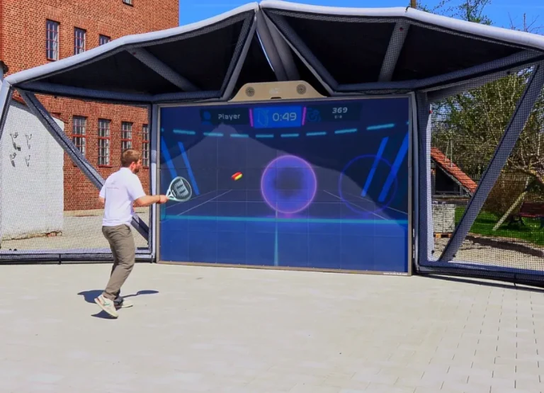 Entrenamiento o juego de tenis individual en simulador con tecnología interactiva y marco exterior.