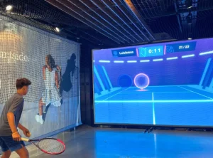 Experiencia de juego de tenis virtual con pantalla interactiva y la marca Lululemon en un evento de activación