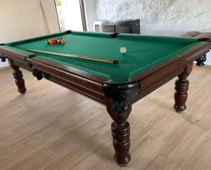 Mesa de billar de estilo clásico con patas torneadas y paño verde.