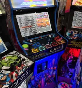 Máquina recreativa de estilo retro con monitor vertical, joystick y botones de colores, con gráficos de arte pop y temas de juegos de lucha.