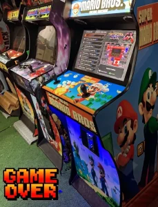 Vista lateral de dos máquinas recreativas con gráficos de Dragon Ball Z y Super Mario Bros.