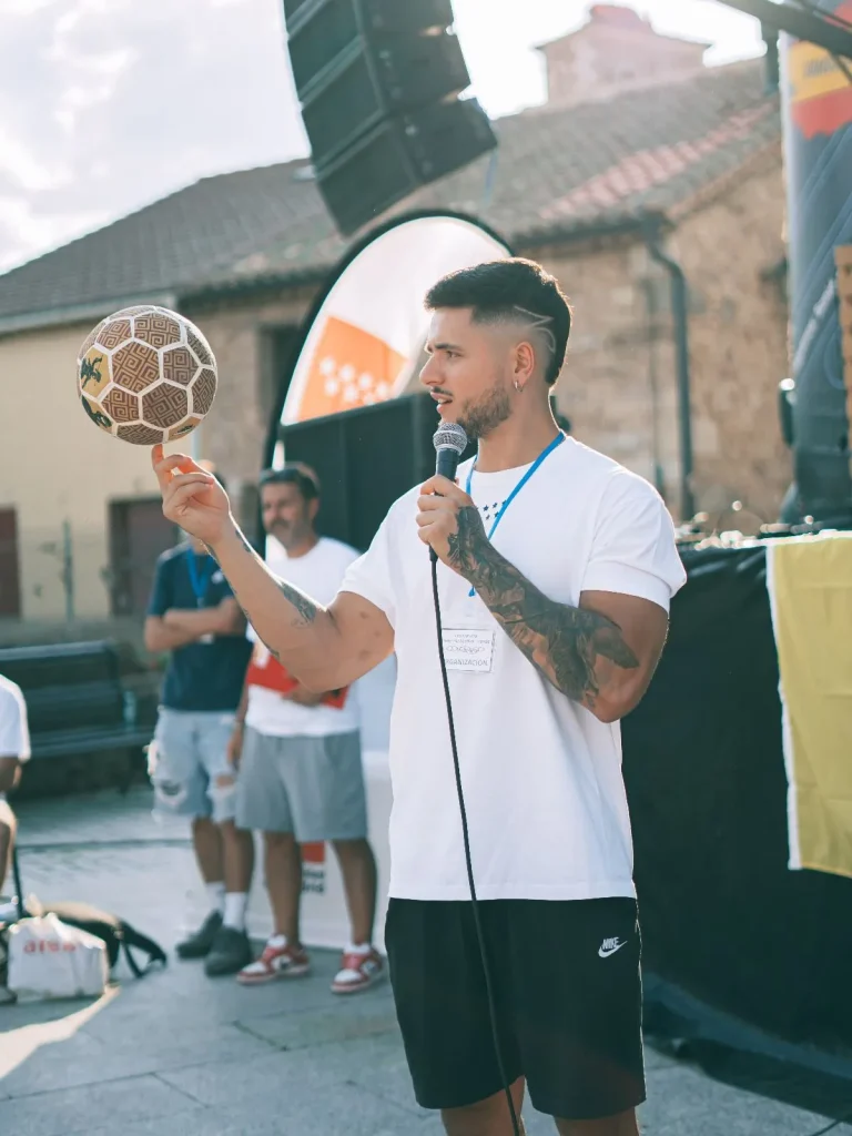 Speaker / Animador de eventos de fútbol freestyle con balón en la mano.