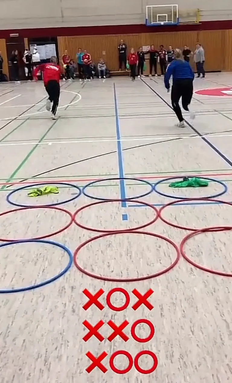 Una persona corriendo a través de una hilera de círculos de colores con marcas de "Tres en raya" (Tic-Tac-Toe) pintadas en el suelo de un gimnasio.
