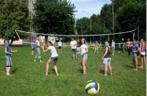 Partido de voleibol sobre césped en un entorno natural rodeado de árboles, ideal para eventos de verano, convivencias y celebraciones al aire libre.